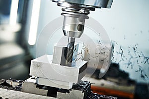 Milling cnc machine at metal work industry. Multitool precision machining. Shallow depth of view on shavings