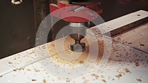 Milling the hole in wood. Worker with milling cutter in action. Countersink drill bit make sink in hole. Man uses