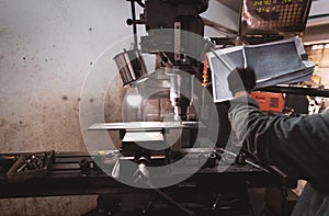 Milling machine working near worker with gloves. Tool for cut metal workpiece. Vertical milling machine with cemented carbide