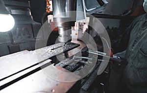 Milling machine working near worker with a protective mask. Tool for cut metal workpiece. Vertical milling machine with cemented