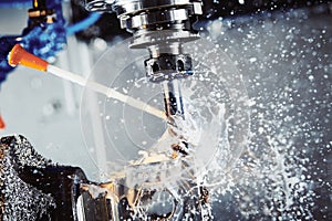 Milling metalworking process. Industrial CNC metal machining by vertical mill. Coolant and lubrication