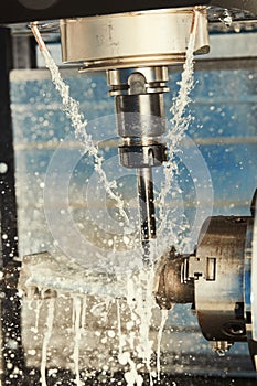 Milling metalworking process. Industrial CNC metal machining by vertical mill. Coolant and lubrication