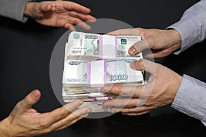 million rubles in men's hands. Bribery in Russian rubles in a dark room. One man gives money another takes it. concept of