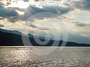 Millstaettersee - A pair of swans landing on Millstaetter lake in Austria during the sunset. The lake is surrounded by high Alps