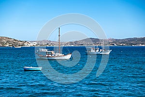 Milos Greek island, Cyclades. Fishing boat moored in open Aegean calm sea, blue sky background