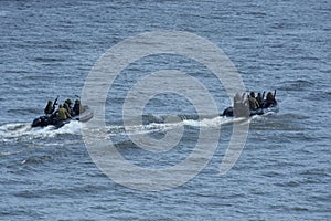 Miltary boats floating on water, armed soldiers of Special Forces aboard