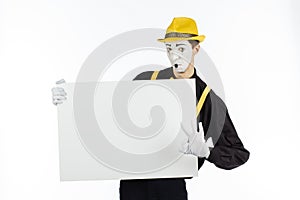 MIME, actor, young man holding white panel with space for text.