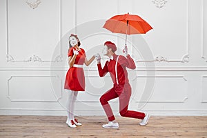 Mime artists in red costumes, scene with umbrella