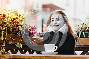 Mime comedian drinking coffee. girl mime drinks coffee in paris