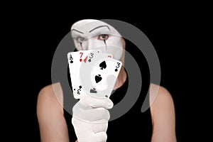 Mime with playing cards on black background