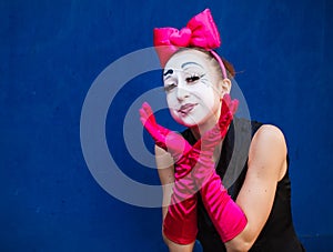 Mime portrait near a blue wall.  on blue background