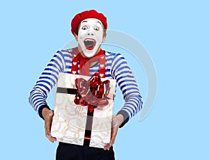 Mime with present.Emotional funny actor wearing