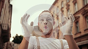 Mime pretends holding something invisible in hands, then throws it over camera.