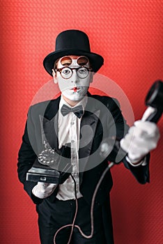 Mime theater actor performing with old telephone