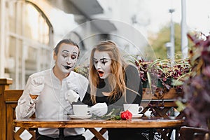 Mimes in front of Paris cafe acting like drinking tea or coffee