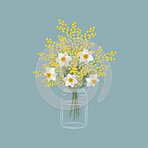 Mimosa and daffodils in a glass jar. Yellow and white flowers with leaves. Spring flowers