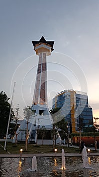 A minaret of a dashing mosque in the city in the evening