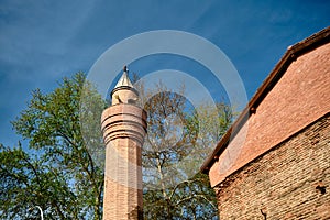 Minaret made of red bricks and tree in Bursa, Nicaea photo