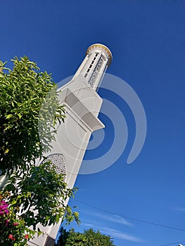 The minaret of a mosque with a clear sky in the background