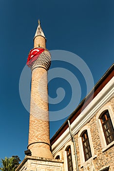 Minaret on a mosque with Turkish flag