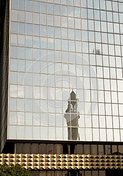 A minaret reflection from a modern building