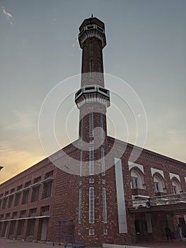 minaret of a msjid in the blue and orange sky in evening time photo