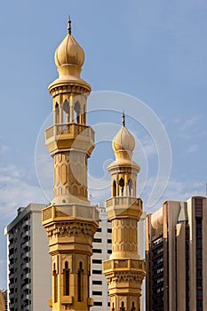 Minarets of the mosque against modern buildings in Abu Dhabi, UAE