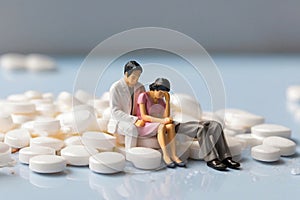 minature asia family sitting on white tablet pills ,Health care and medical industry business concept