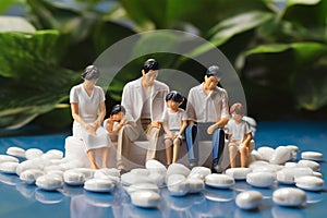 minature asia family sitting on white tablet pills ,Health care and medical industry business concept