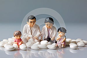 minature asia family sitting on white tablet pills ,Health care and medical industry business concept