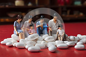 minature asia family sitting on white tablet pills ,Health care and medical industry business concept