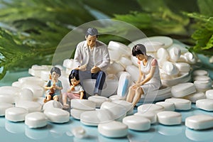 minature asia family sitting on white tablet pills ,Health care and medical industry business concept