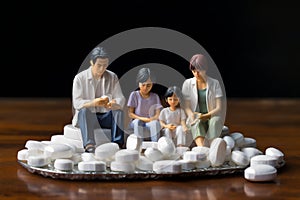 minature asia family sitting on white tablet pills ,Health care and medical industry business concept