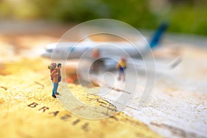 Minature people: traveling with a backpack standing on vintage world map and plane,  Travel and vacation concept.