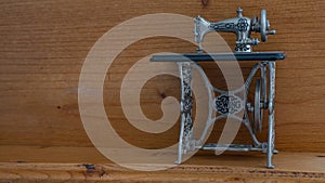 Minature sewing machine against wooden background