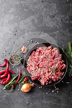 Mince. Ground meat with ingredients for cooking on black background