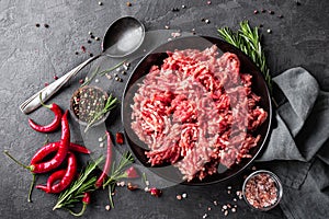 Mince. Ground meat with ingredients for cooking on black background