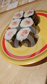 Minced Japanese tuna maki on a yellow plate.
