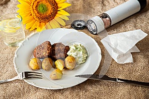 Minced meat balls, potato and dip, open salt cellar and sunflower