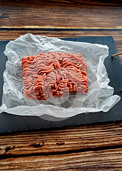 Minced meat on cooking paper and stone tray