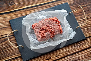Minced meat on cooking paper and stone tray