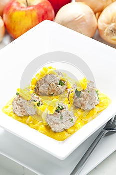 minced meat and herbs balls in apple and curry sauce