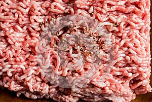 Minced pork, Minced meat texture close up - top view minced meat raw fresh macro. Close-up with pepper, salt spices cooking cutlet