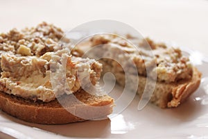 Mincemeat of herring on a slice of brown bread on white background close up view