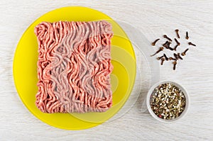 Mincemeat on plate, carnation, condiment on wooden table