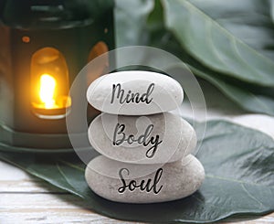 Mind, Body and Soul words engraved on zen stones with black lamp background. Zen concept