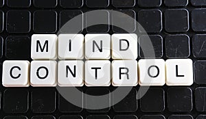 Mind control text word title caption label cover backdrop background. Alphabet letter toy blocks on black reflective background. W