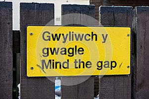 Mind the gap warning sign on railway platform