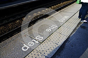 Mind the step sign on railway platform floor