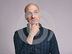 Minded man in shirt touching his chin